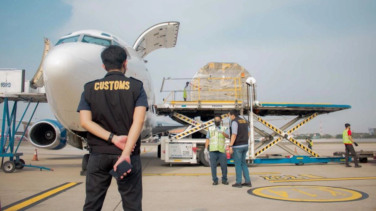 Customs officer overseeing air cargo loading beside an aircraft, customs clearance support